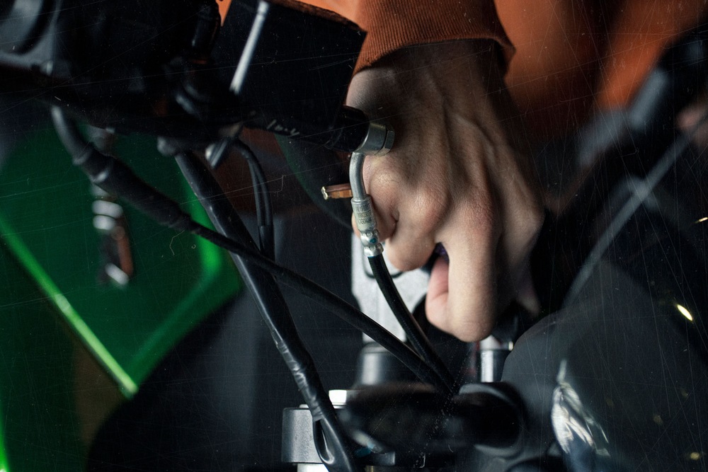closeup image of a mechanics hand unscrewing a component
